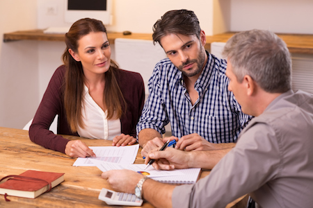 A couple consults with a real estate lawyer for their real estate transaction