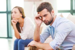 A man holds his head and thinks about the different options for getting a divorce