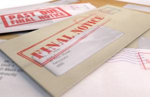 An envelope of overdue debt payments sits on a table after a divorce