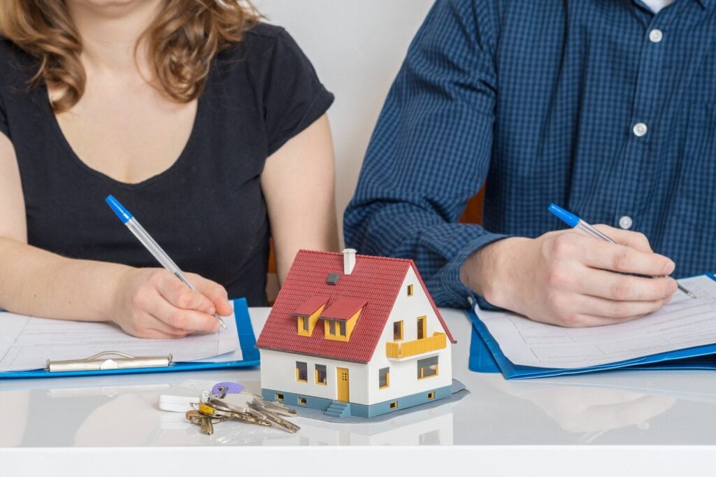Divorce and dividing a property concept. Man and woman are signing divorce agreement.