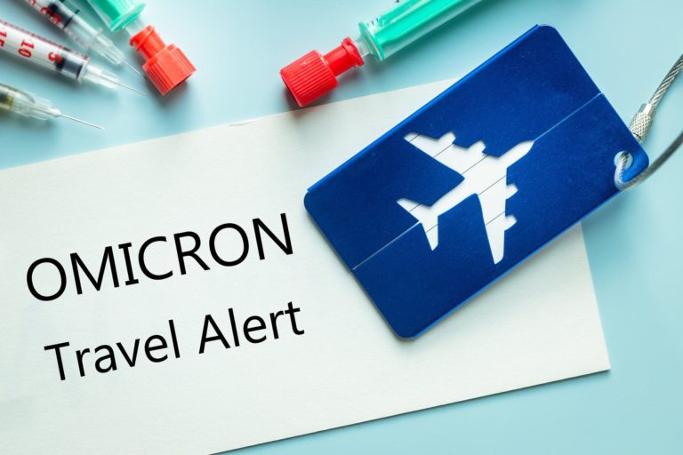Luggage tag for the plane, syringes and a card with the words Omicron, Travel Alert, The concept of stopping flights from Africa due to a new virus mutation