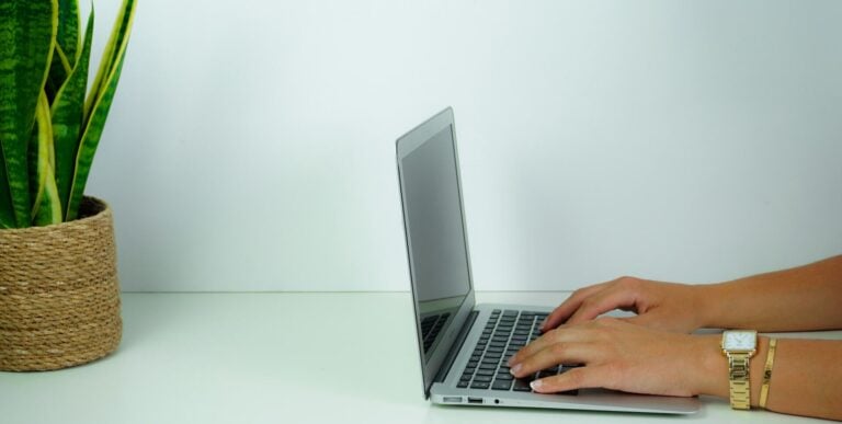 Person typing on a modern laptop at a contemporary desk.